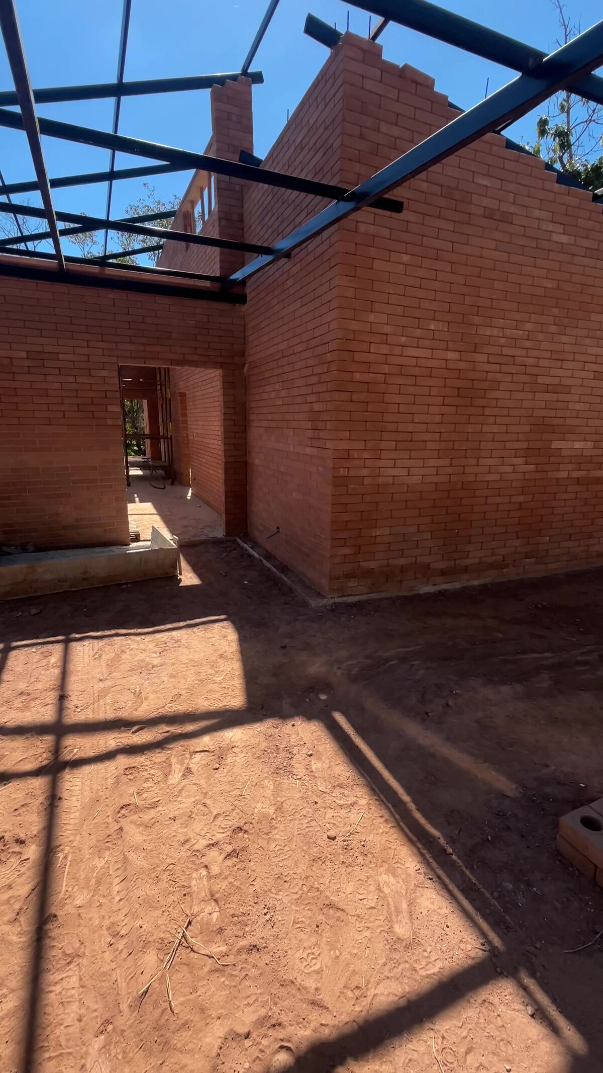 Estrutura metálica da cobertura sobre as paredes de tijolo ecológico